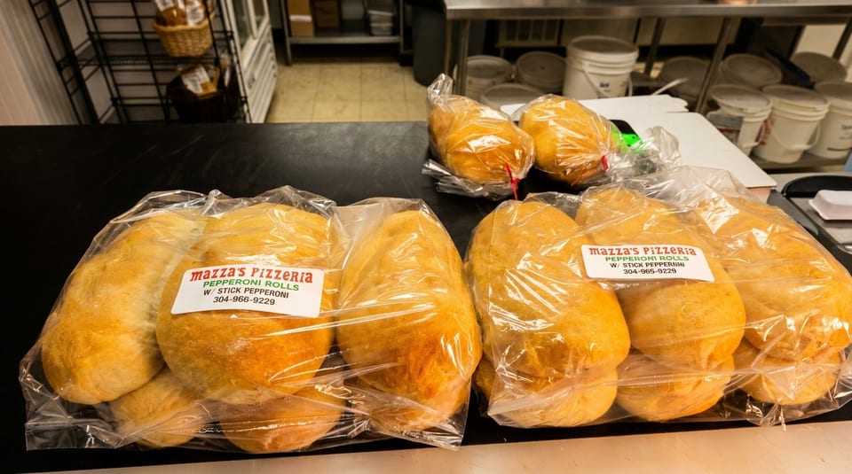 Several bags of Mazza's Pizzeria pepperoni rolls with stick pepperoni sit on a counter.